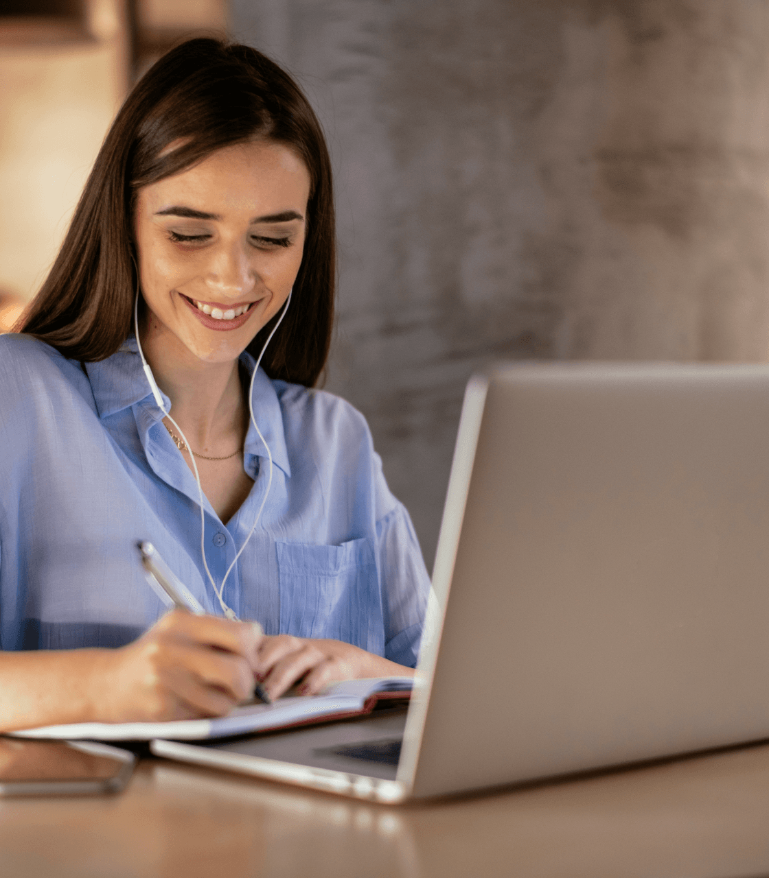 Woman smiling while working on laptop for transformative learning with academy.