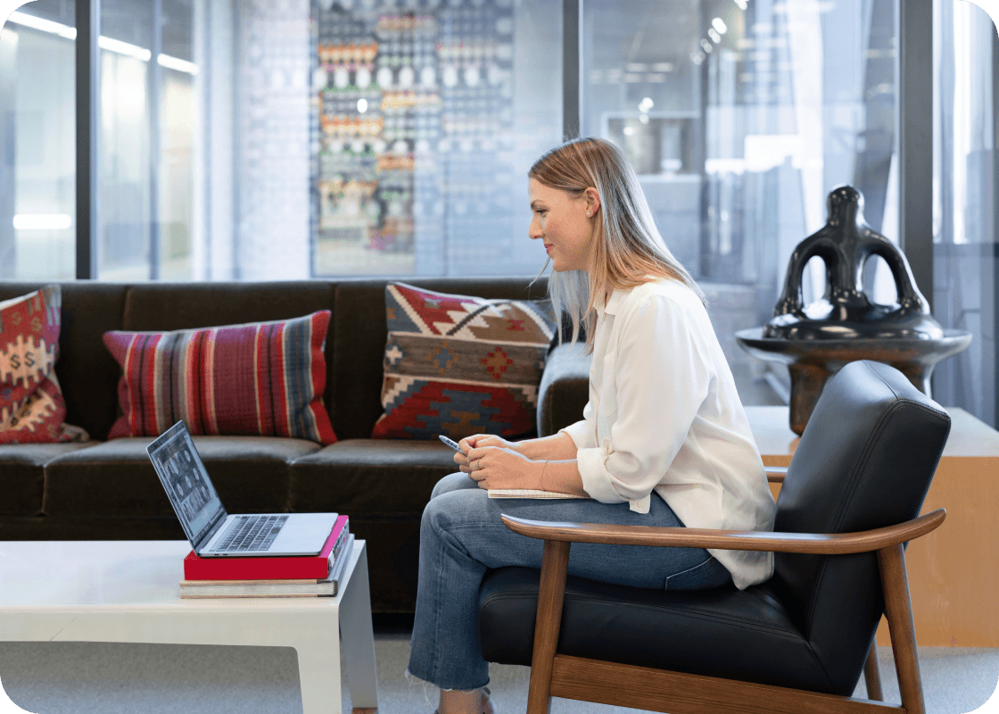 A woman sitting in a chair, ready to unlock meeting success with step-by-step guides to improve communication and leadership skills.