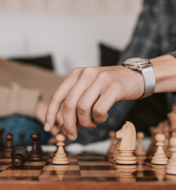 A formal setting on a bed where two people are playing chess, exemplifying the Spiky vs. Gong revenue intelligence approach.