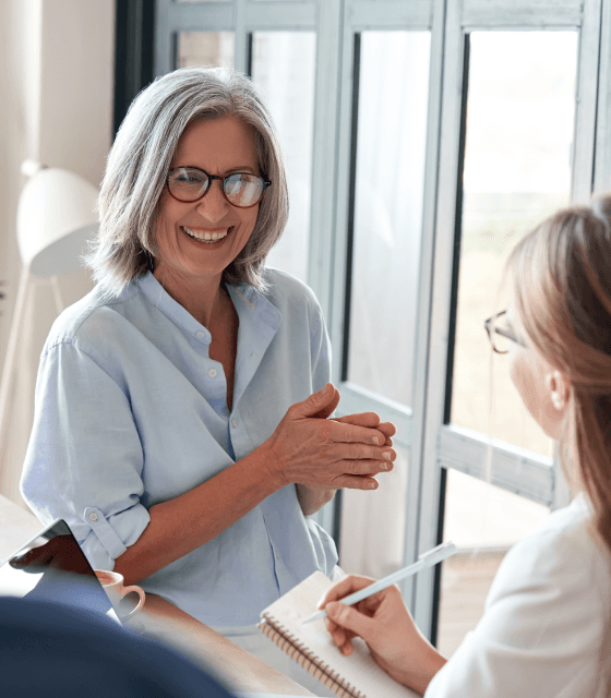 Two women engaging in a conversation, one wearing glasses, discussing the efficient use of objective data and expert techniques for improvement.