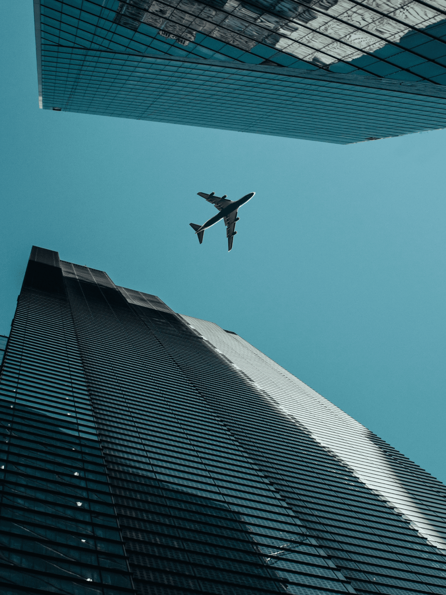 The seamless integration of flight and metropolitan structures is exemplified as an airplane gracefully glides over a majestic high-rise.