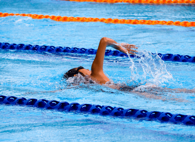 A swimmer glides through a pool with blue and orange lanes. The 80-20 rule reminds us that some tasks require more time and effort than others.